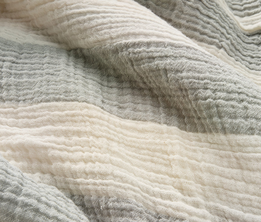 Gros plan d'un tissu plissé à rayures grises et blanches.