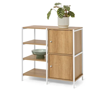 Un buffet avec deux portes et trois étagères ouvertes se dresse devant un fond blanc. Une plante en pot est posée sur le buffet et un bol vert est posé sur l'une des étagères ouvertes.