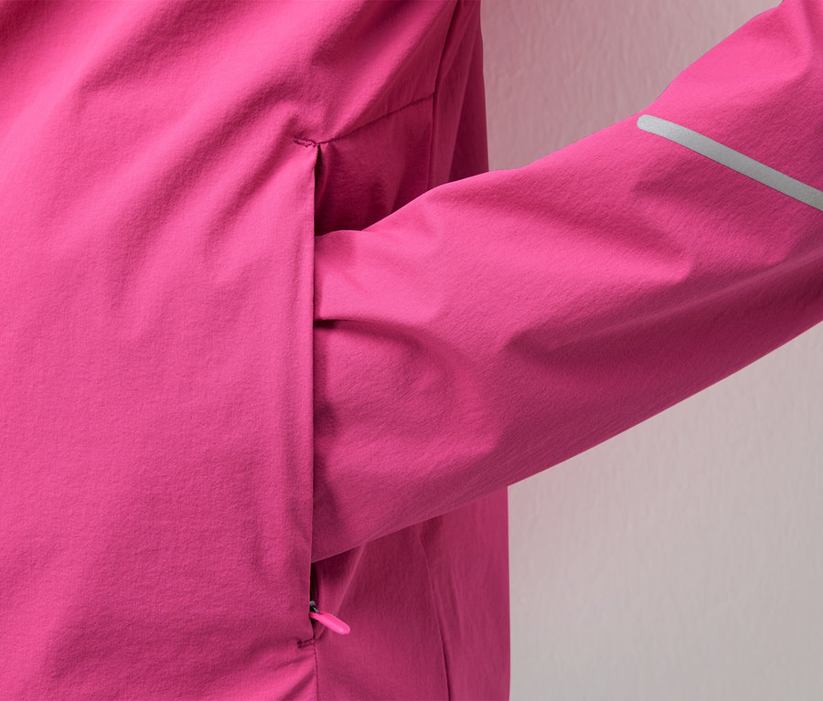 Gros plan d'une veste rose avec une bande réfléchissante sur la manche.