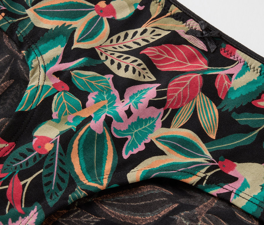 Gros plan d'une culotte noire avec un motif floral tropical.