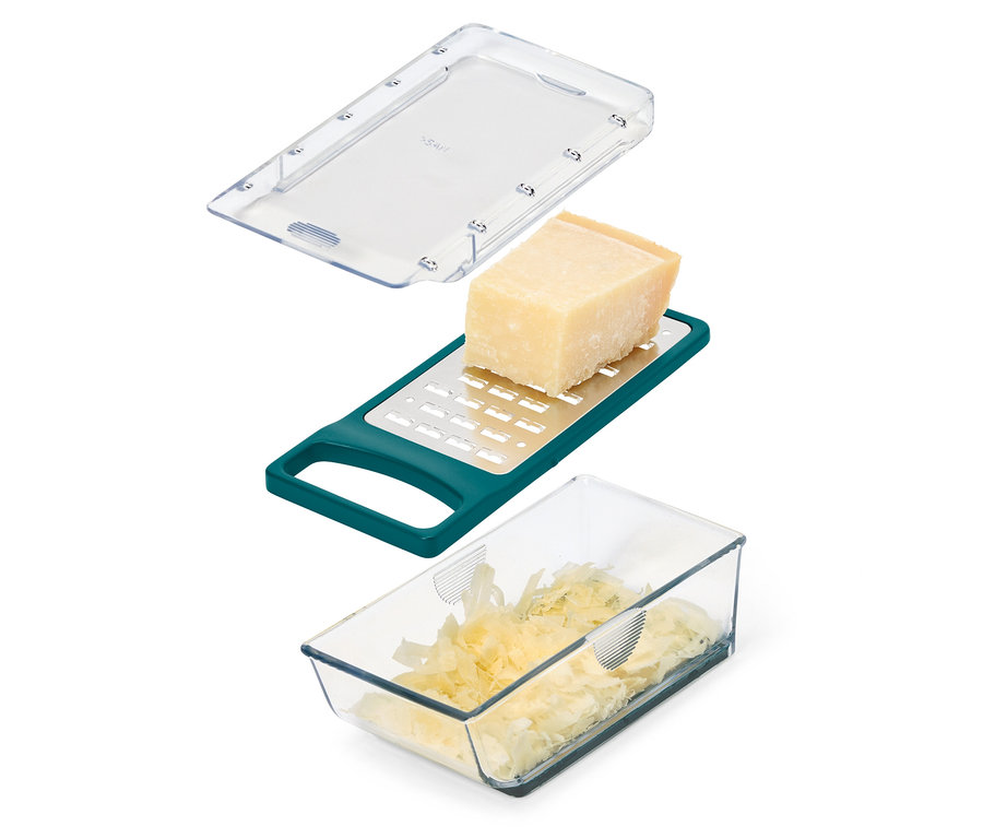Bloc de fromage sur une râpe verte avec récipient et couvercle.