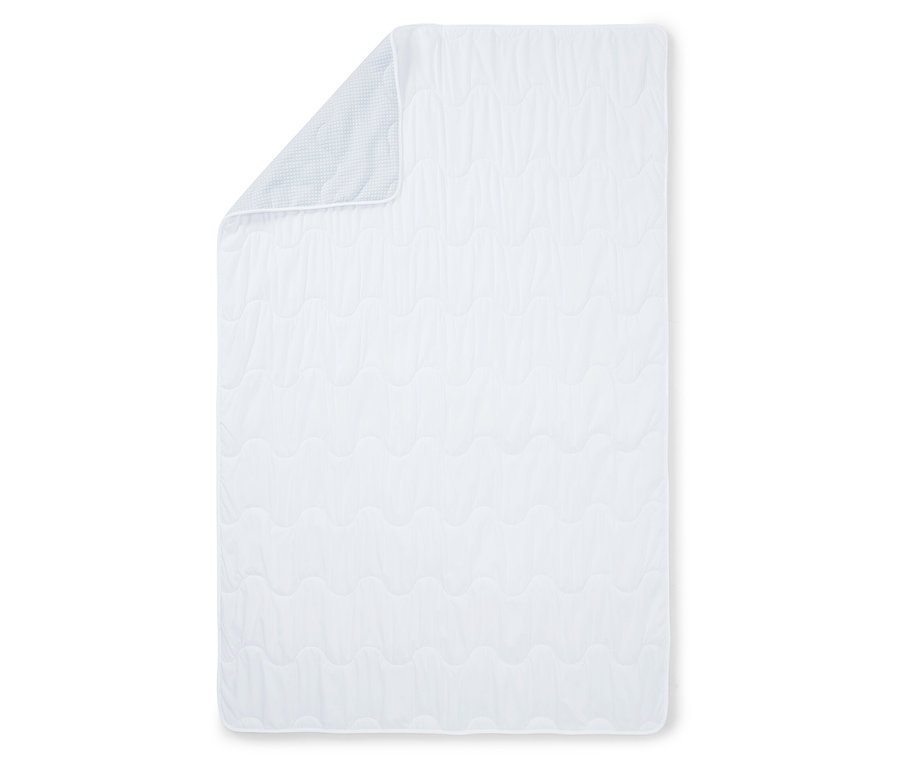 Tapis d'éveil blanc matelassé avec un coin replié révélant un motif à carreaux bleu clair.