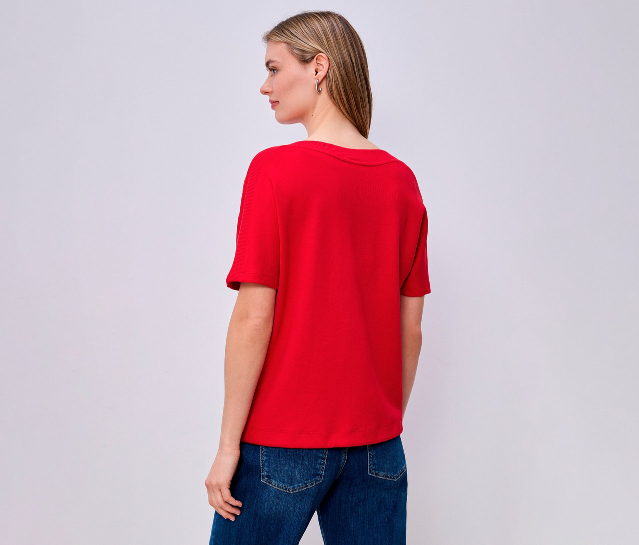 Femme vue de dos portant une chemise à manches courtes rouge Street One et un jean.