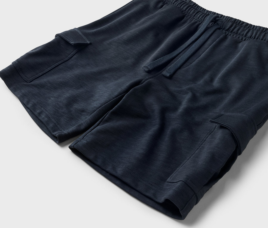 Gros plan d'un short bleu marine avec cordon de serrage et poches cargo.