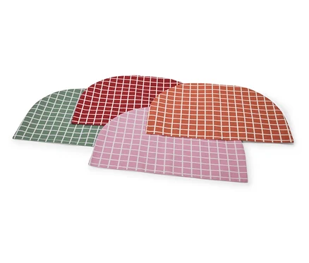 Quatre bonnets de douche colorés à carreaux, vert, rouge, orange et rose, sont superposés.