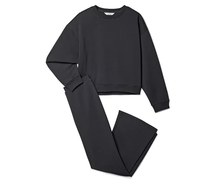 Un sweat-shirt gris et un pantalon gris sont posés sur un fond blanc.