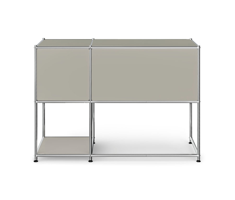 Meuble modulaire avec cadre chromé et panneaux gris clair, composé de deux compartiments supérieurs fermés, d'une étagère ouverte en bas à gauche et d'un espace ouvert en bas à droite.