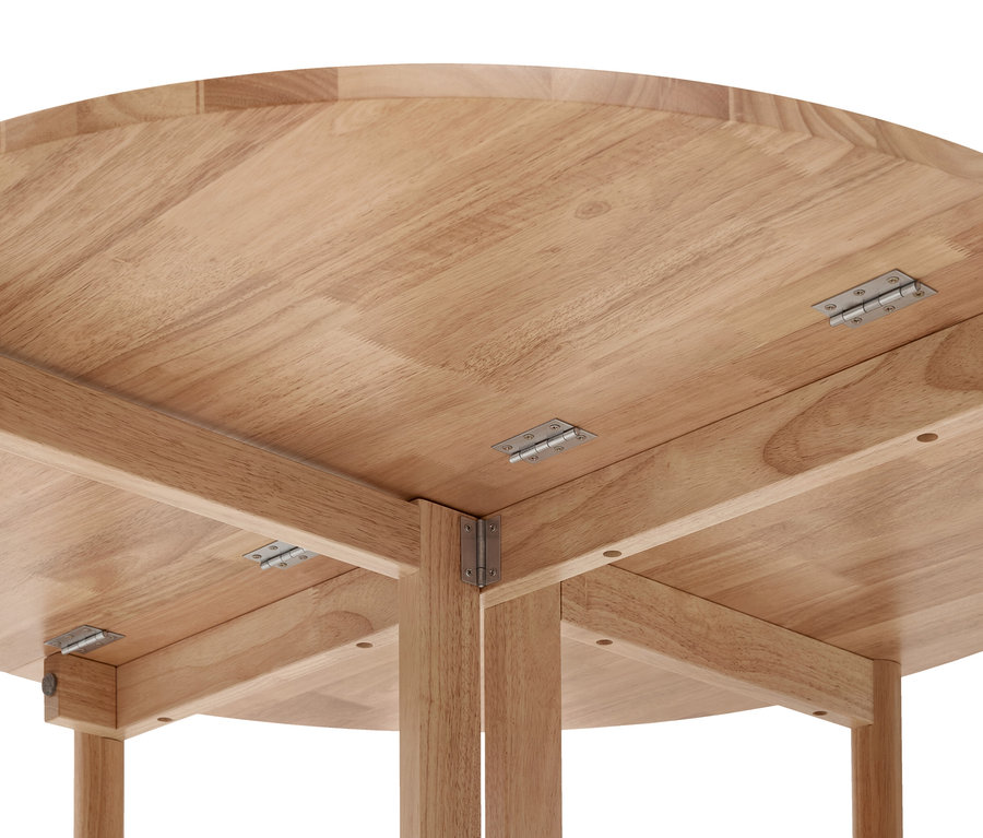 Dessous d'une table en bois clair avec un plateau rond, des charnières métalliques et des pieds en bois.