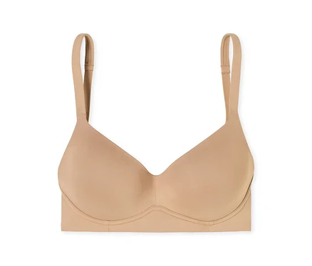 Un soutien-gorge beige sans coutures avec des bonnets moulés et des bretelles réglables.