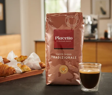 Un paquet de Piacetto Caffè Crema Tradizionale, du café et des croissants sur une table.