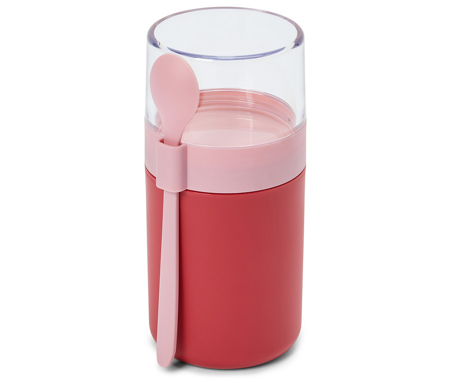 Un récipient alimentaire rouge avec une bande rose et un couvercle transparent, doté d'une cuillère rose attachée sur le côté.