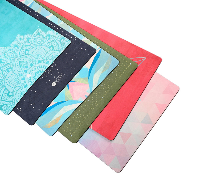 Gros plan de sept tapis de yoga aux motifs différents empilés les uns sur les autres.