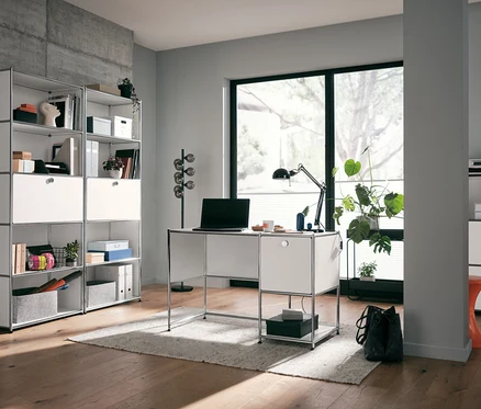Pièce avec bureau en métal «
CN3
» avec porte abattante, blanc, chaise cantilever et étagère haute en métal «
CN3
» avec abattant, blanche.