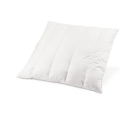 Gros plan d'un oreiller blanc matelassé garni de copeaux de pin cembro.