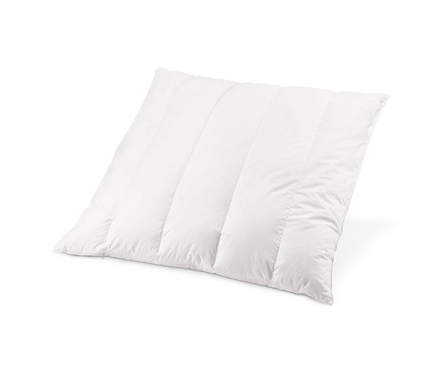 Gros plan d'un oreiller blanc matelassé garni de copeaux de pin cembro.