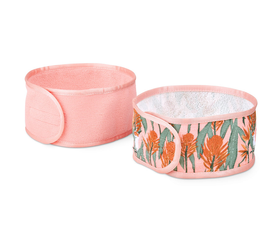 Deux bandeaux cosmétiques : un rose uni et un avec un motif tropical.