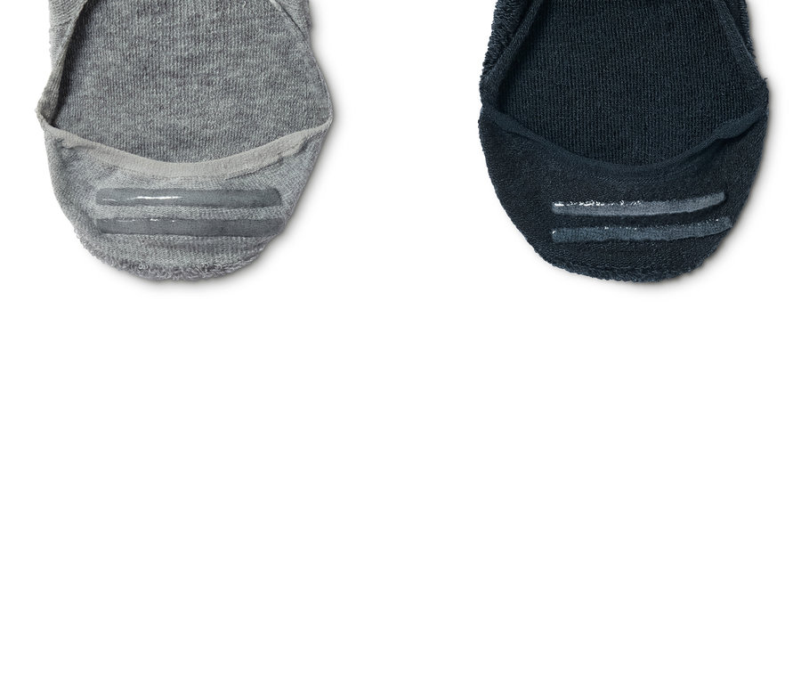 Gros plan de deux paires de socquettes de sport, une grise et une bleu marine.