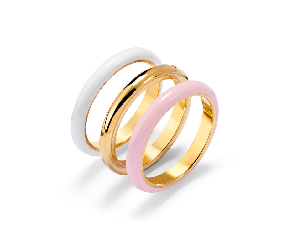 Gros plan de trois bagues : dorée, blanche et rose.