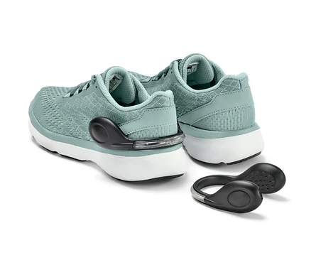 Deux baskets bleu clair avec 2 clips pour chaussures à LED sur fond blanc.