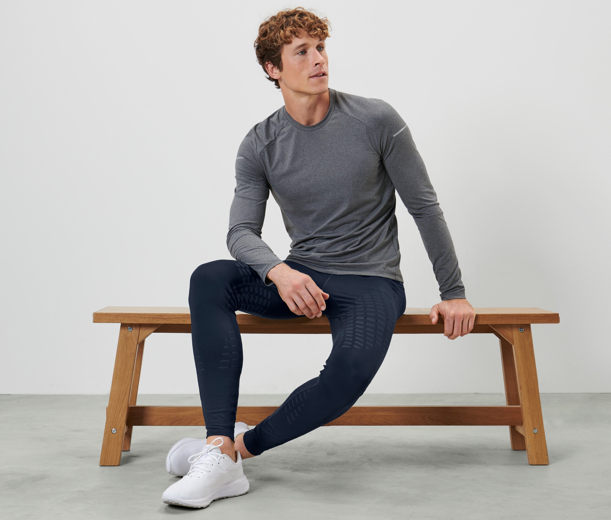 Homme assis sur un banc portant un legging de sport.
