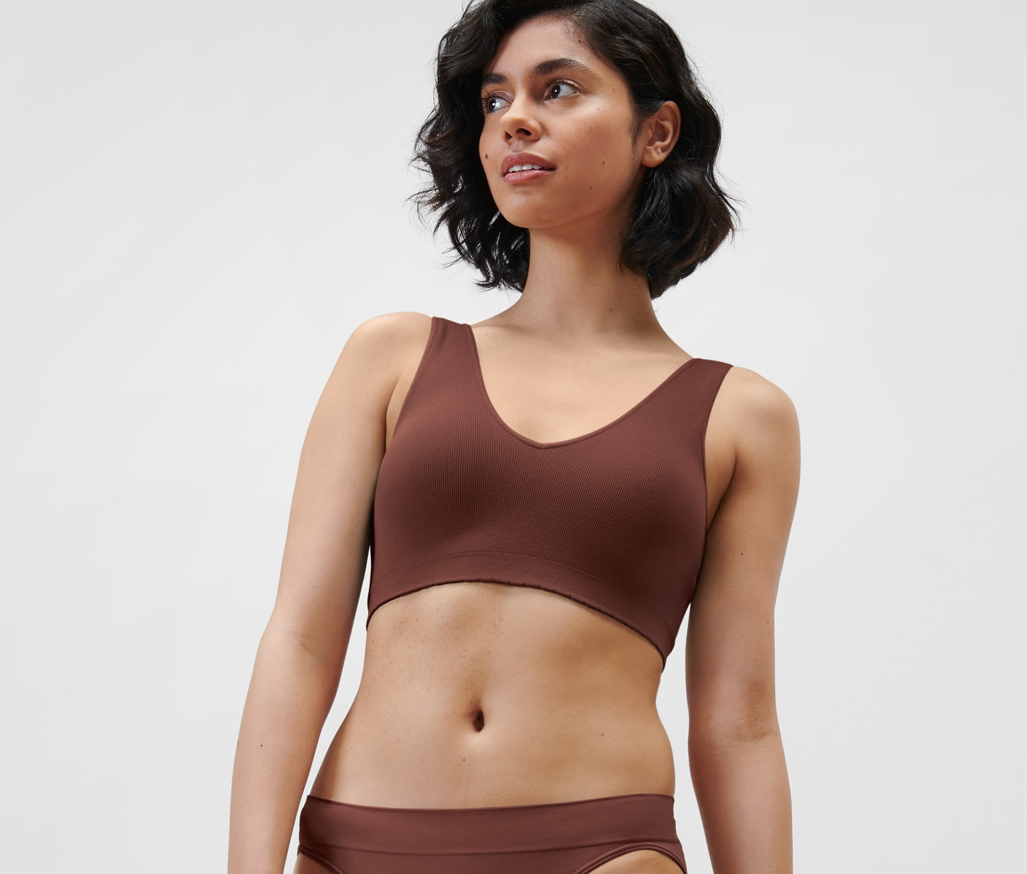 Une femme portant une brassière seamless marron.