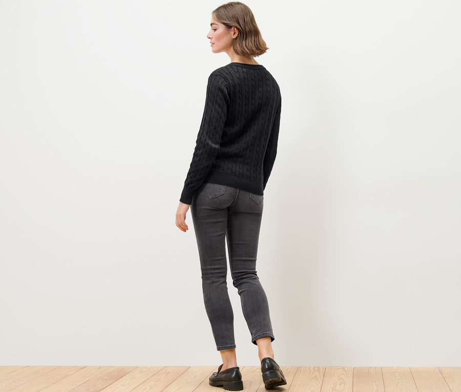 Femme portant un cardigan en maille fine à motif torsadé, un jean et des mocassins.