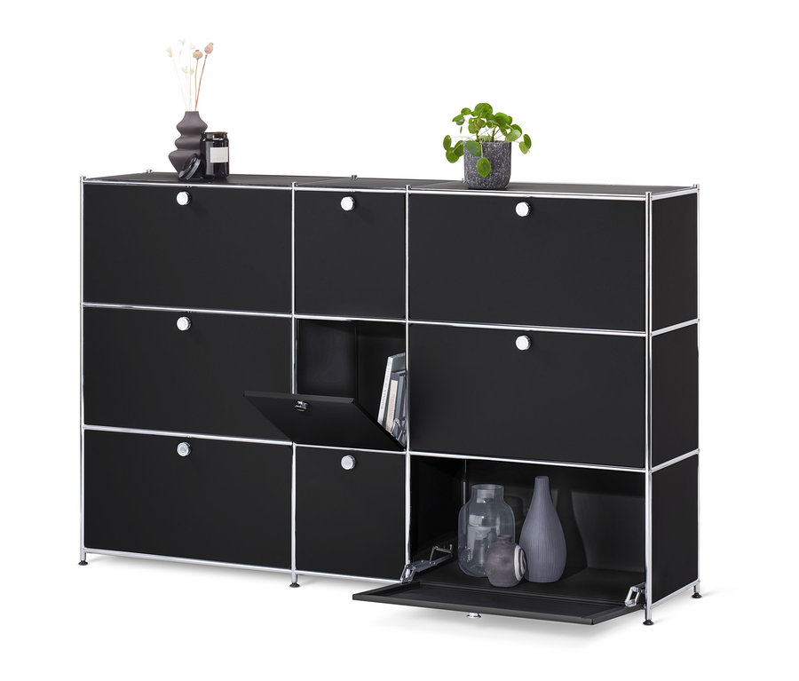 Commode « CN3 » noire avec 9 abattants, dont un ouvert et révélant des livres et deux ouverts et révélant des vases.