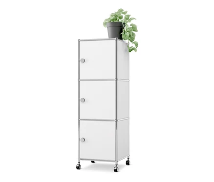 Caisson en métal blanc à roulettes «CN3» avec 3 portes, surmonté d'une plante verte en pot.
