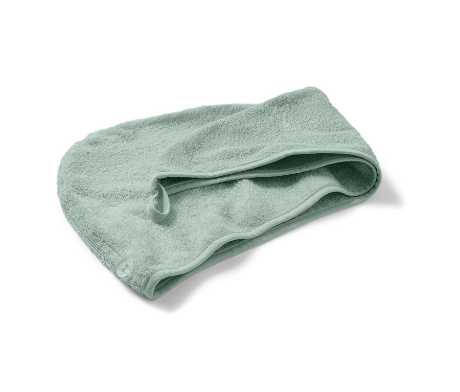 Une serviette turban verte sur fond blanc.