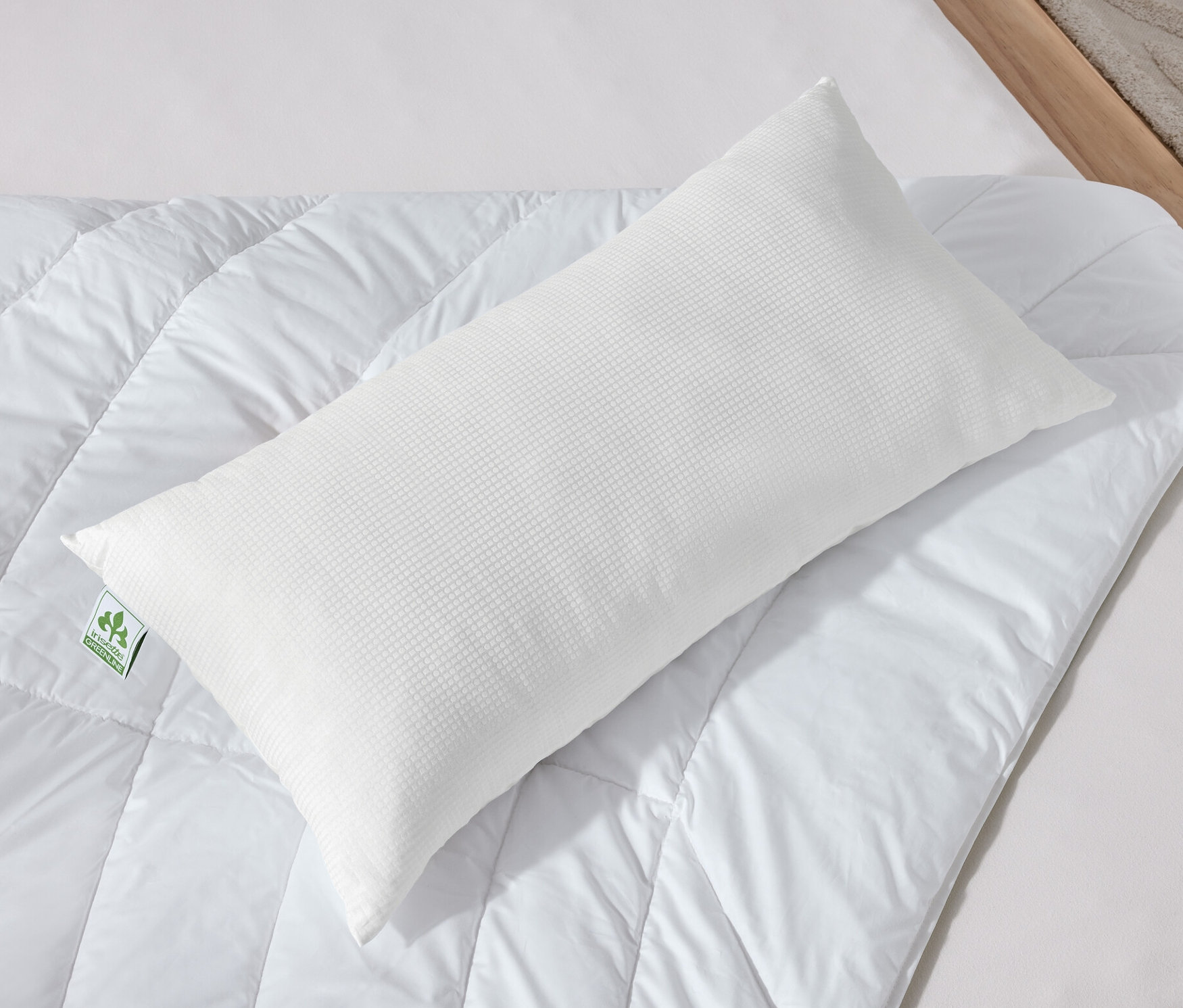 Deux oreillers blancs irisette® greenline avec technologie Outlast® sont posés sur une couette blanche.