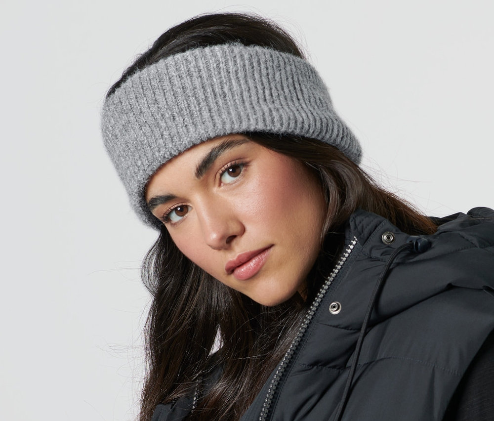 Femme portant un bandeau en maille et une veste noire.