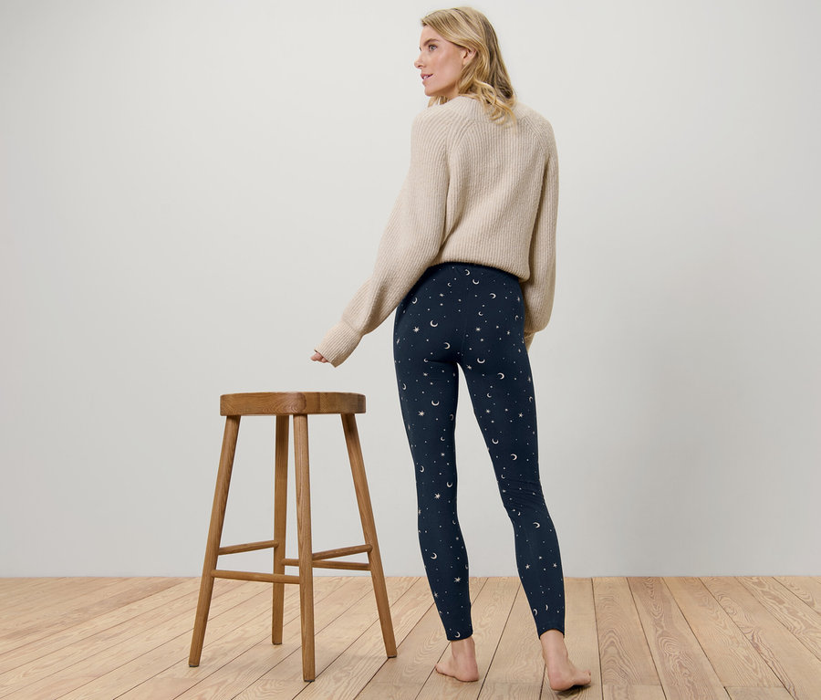 Une femme, vue de dos, porte un legging douillet avec un motif d'étoiles et de lunes.