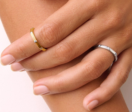 Gros plan d'une main de femme portant une bague Octogone en argent 925 dorée et une bague Octogone en argent 925.