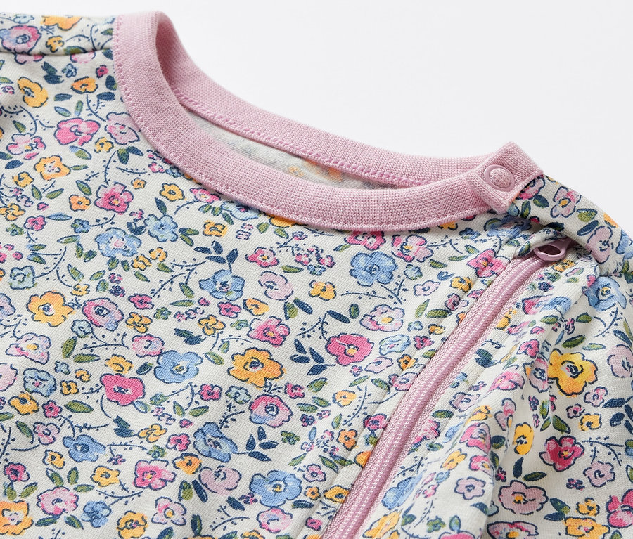 Gros plan sur un pyjama pour bébé avec un motif floral.