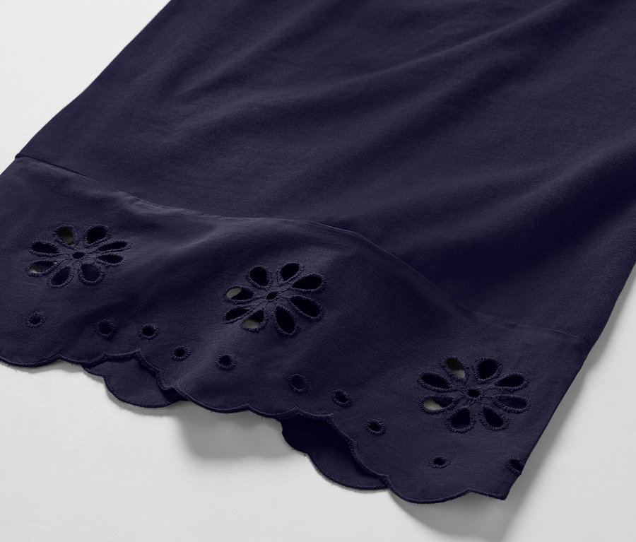 Gros plan sur une culotte bleu marine avec des broderies florales sur l'ourlet.