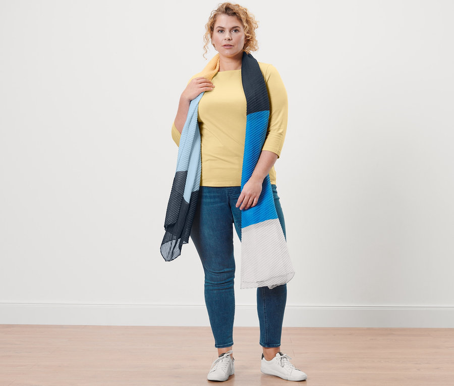 Une femme pose en t-shirt manches 3/4 jaune, tregging « Fit Nelly » et écharpe plissée.