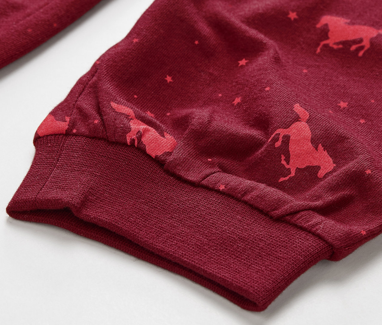 Détail d'un pyjama pour enfant avec un imprimé de chevaux