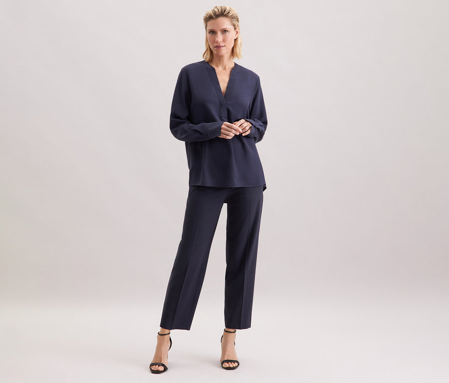 Femme debout portant une tunique en viscose bleu marine Seidensticker.