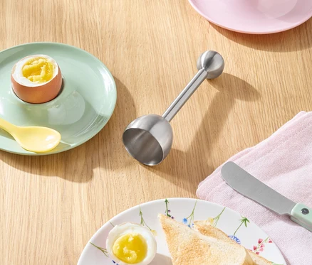 Pain grillé, œufs et couteau sur une table en bois.