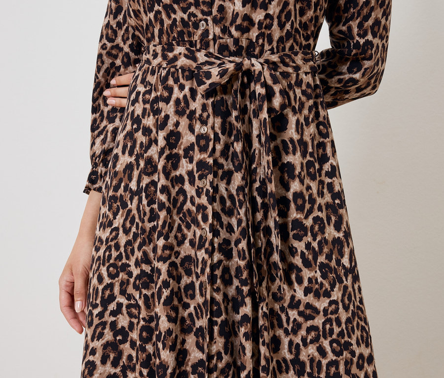 Vue partielle d'une femme portant une robe marron à motif animalier avec une ceinture.