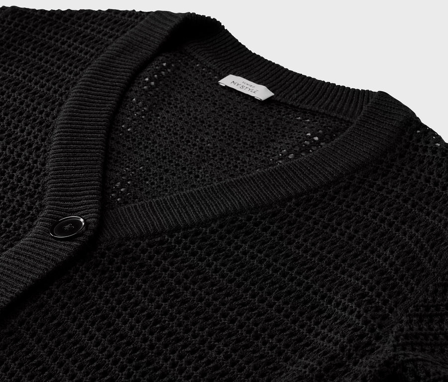 Gros plan sur un cardigan noir en maille pointelle.