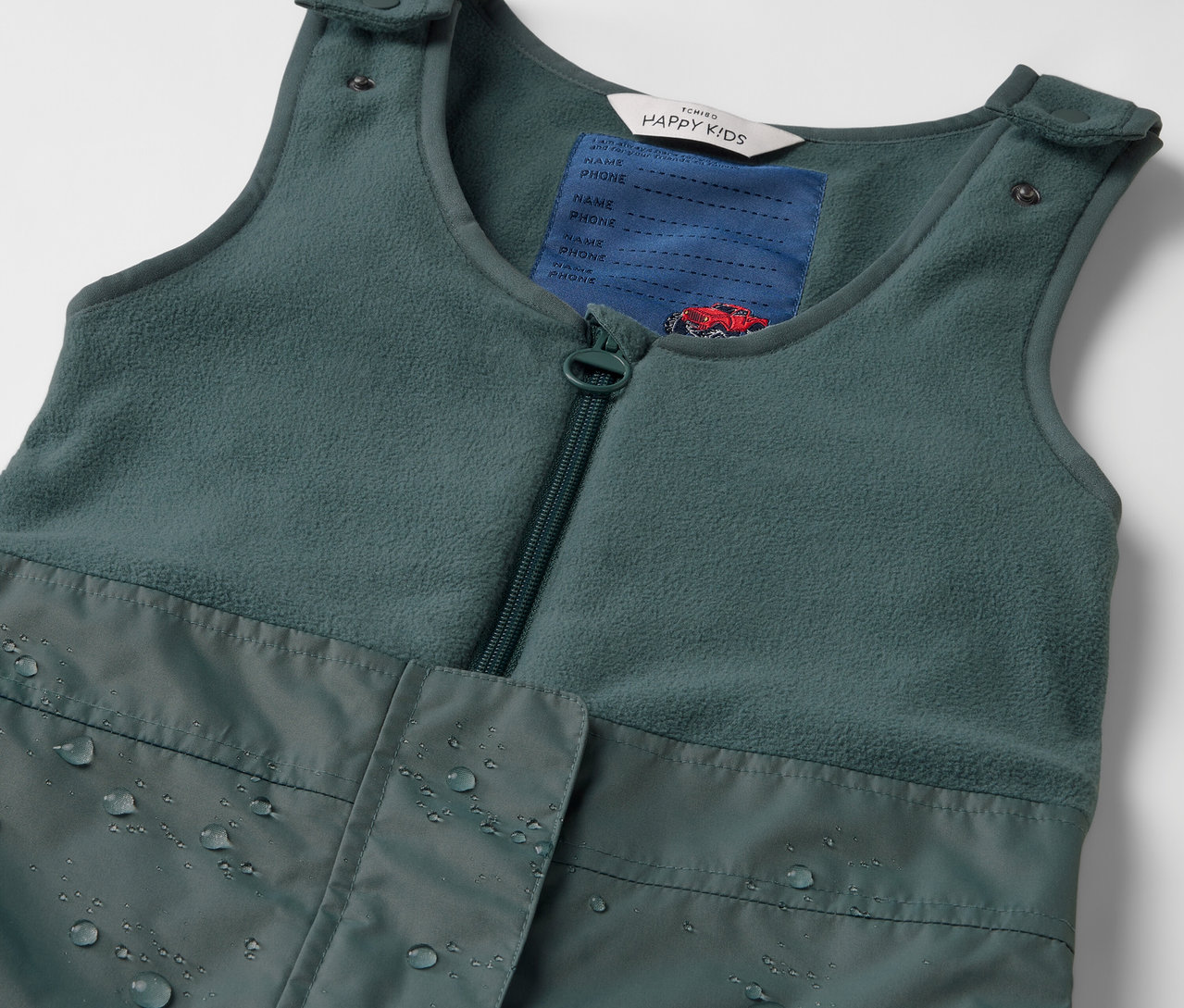 Gros plan sur un pantalon de pluie thermique pour enfant vert.