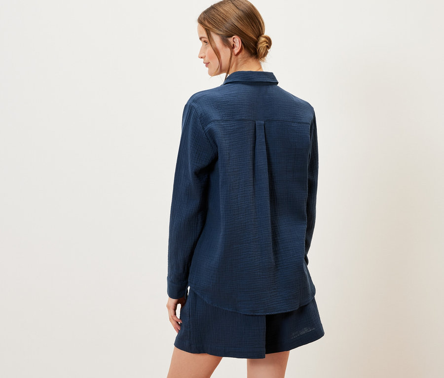 Femme vue de dos portant un chemisier en mousseline bleu marine.