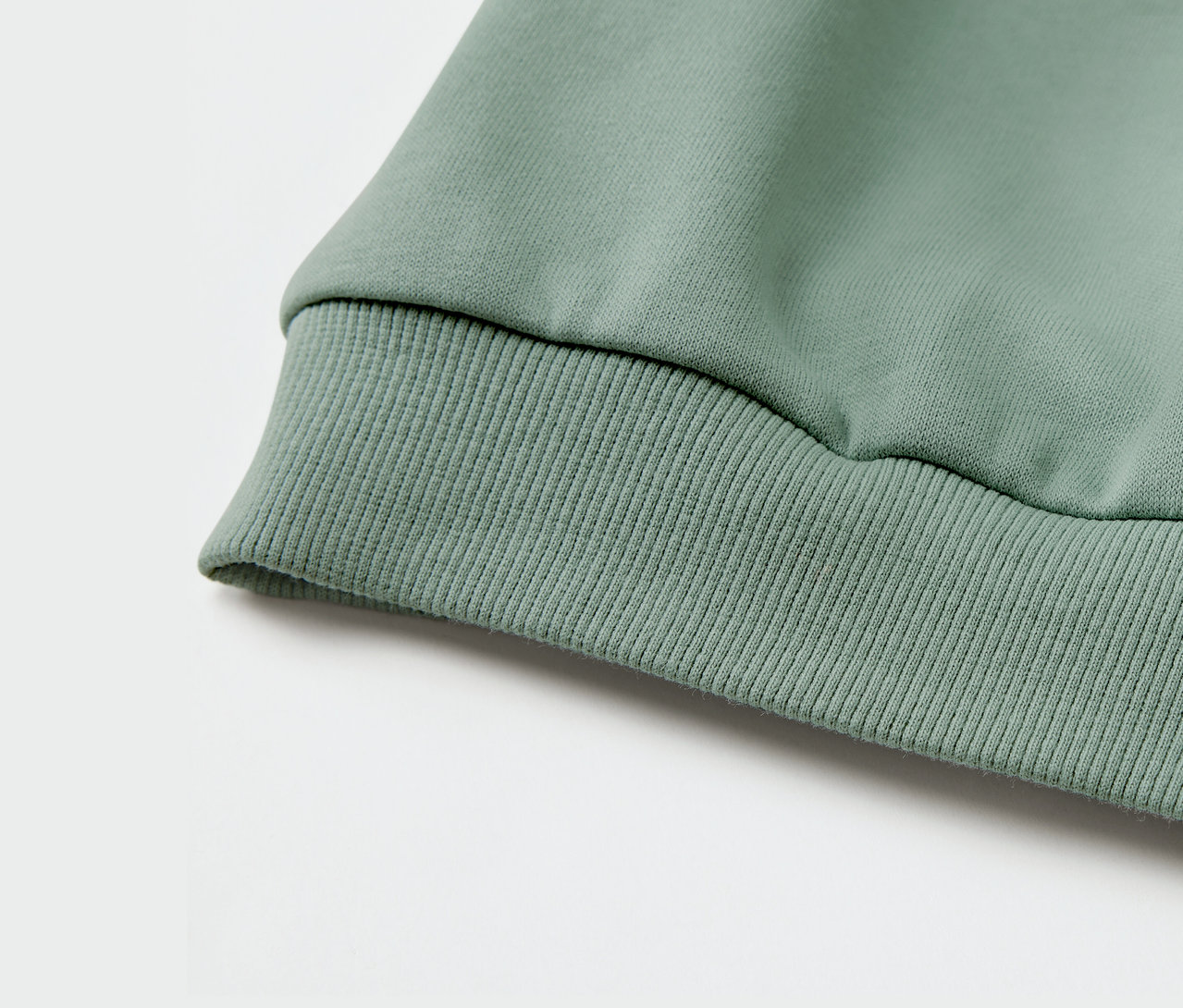 Gros plan sur le bord-côte d'un sweat-shirt vert pour enfant.
