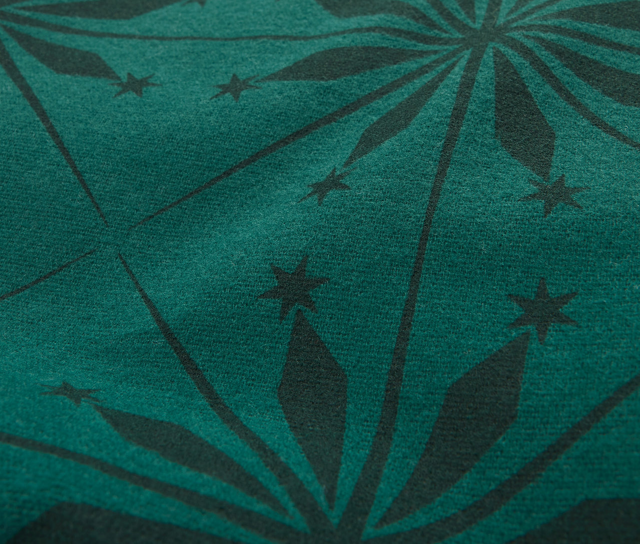 Gros plan d'un tissu vert foncé avec un motif d'étoiles noires.