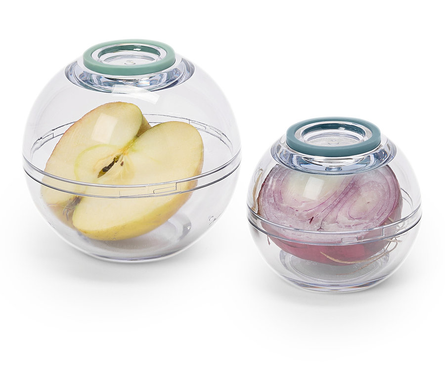 Une moitié de pomme dans un grand récipient transparent et un oignon rouge dans un récipient transparent plus petit.