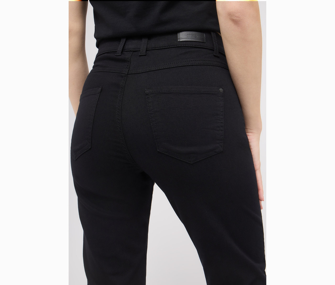 Gros plan de l'arrière d'une femme portant un jean noir Angels Denim «
Lara
», coupe droite.