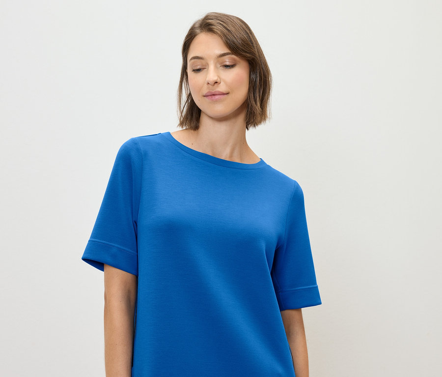 Femme portant un t-shirt bleu.