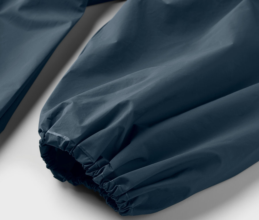 Gros plan sur la manche d'un poncho de pluie bleu.