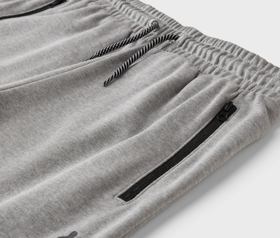 Gros plan d'un pantalon de jogging gris avec cordon de serrage et poche zippée.